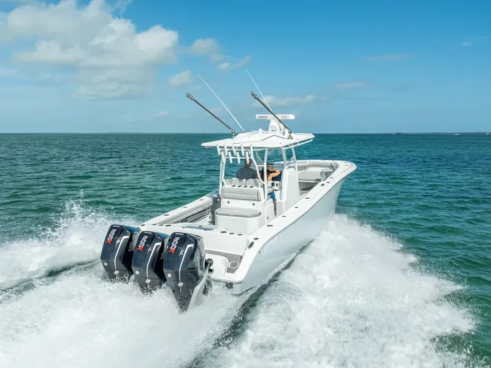  Yacht Photos Pics 2020 Yellowfin 34 boat cruising on open water with triple outboard engines.