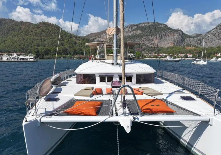  Yacht Photos Pics Lagoon 560 catamaran sailing in scenic bay, 2011 model, with mountains in the background.