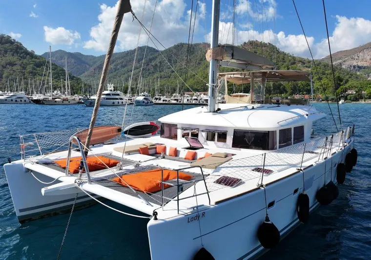  Yacht Photos Pics 2011 Lagoon 560 catamaran anchored in scenic marina with mountains in background.