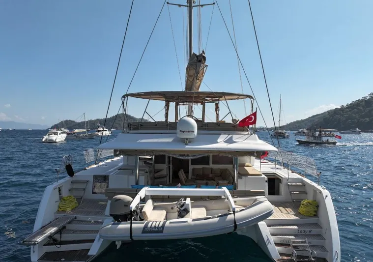  Yacht Photos Pics 2011 Lagoon 560 yacht anchored with tender, surrounded by scenic ocean and boats.