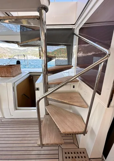  Yacht Photos Pics Spiral staircase on 2011 Lagoon 560 yacht with wooden steps and metal railing.
