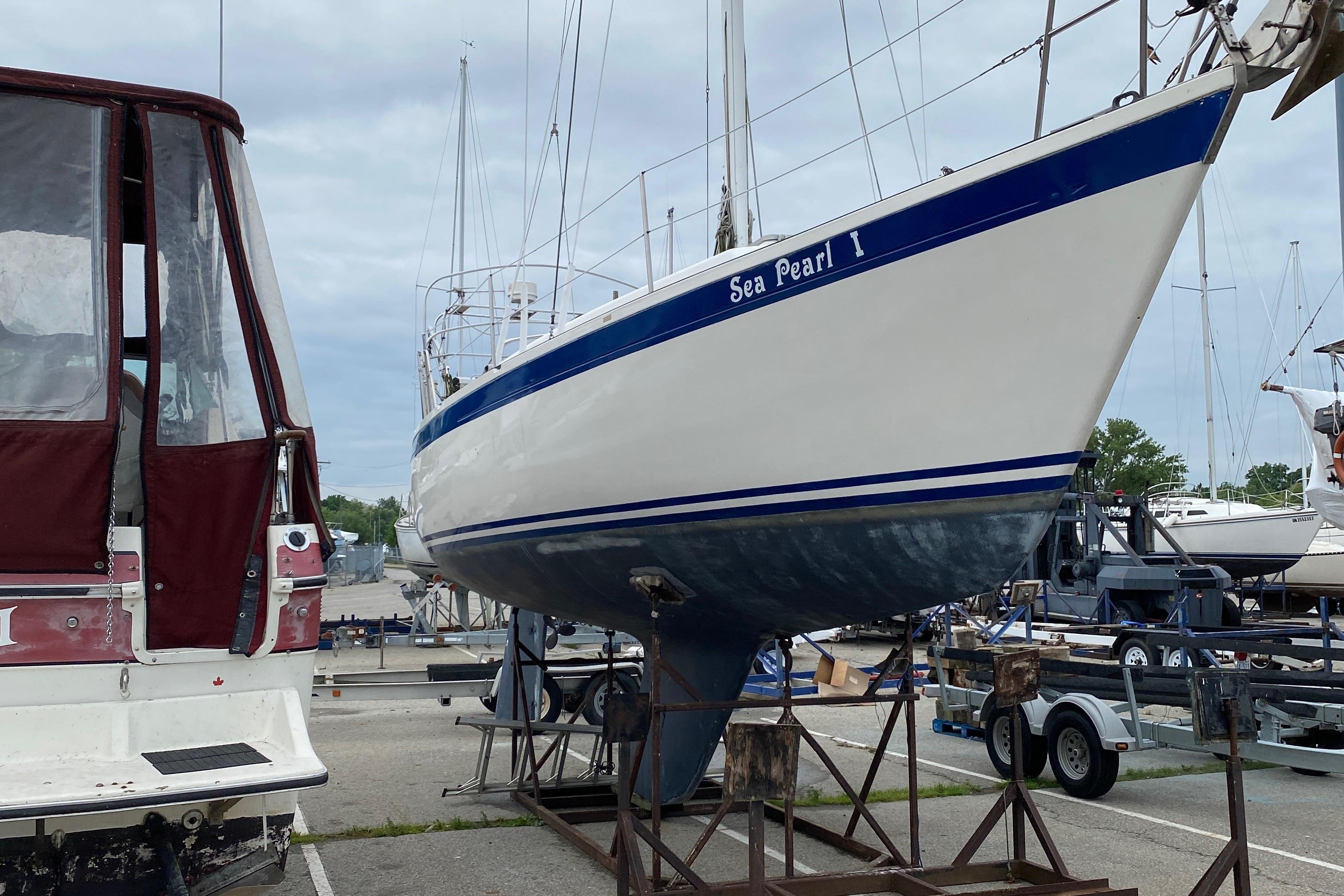 Aloha 34 sailboat from 1985, named "Sea Pearl I," on a boatyard stand.
