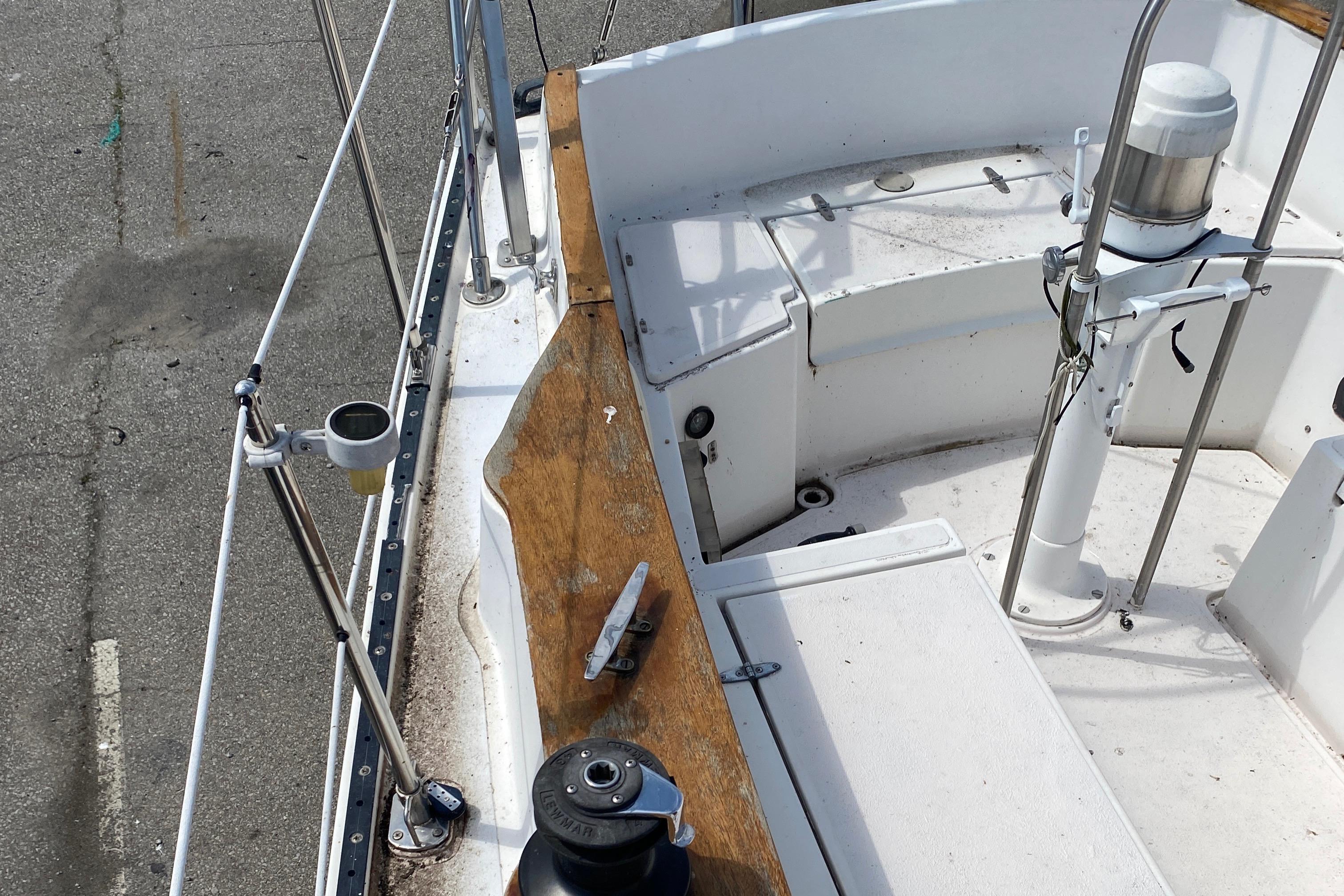 Cockpit of a 1985 Aloha 34 sailboat with wooden trim and winch.