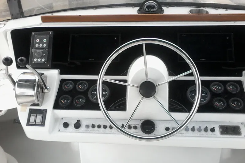 Lusea Yacht Photos Pics 1997 Mainship 350 helm with steering wheel, gauges, and controls.