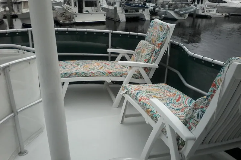 Lusea Yacht Photos Pics 1997 Mainship 350 yacht deck with colorful cushioned chairs in a marina setting.