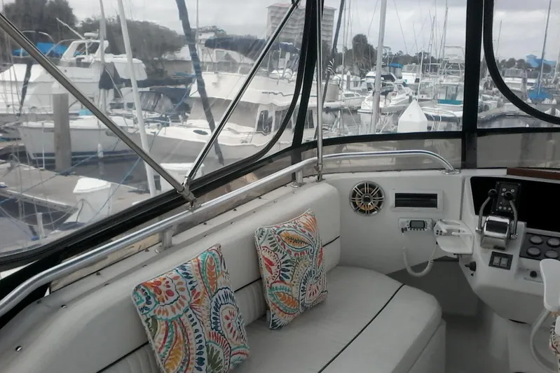 Lusea Yacht Photos Pics 1997 Mainship 350 yacht interior with colorful cushions, docked at a marina.
