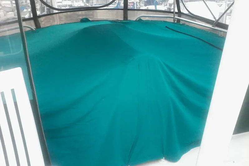 Lusea Yacht Photos Pics Covered deck area of a 1997 Mainship 350 boat with teal fabric.