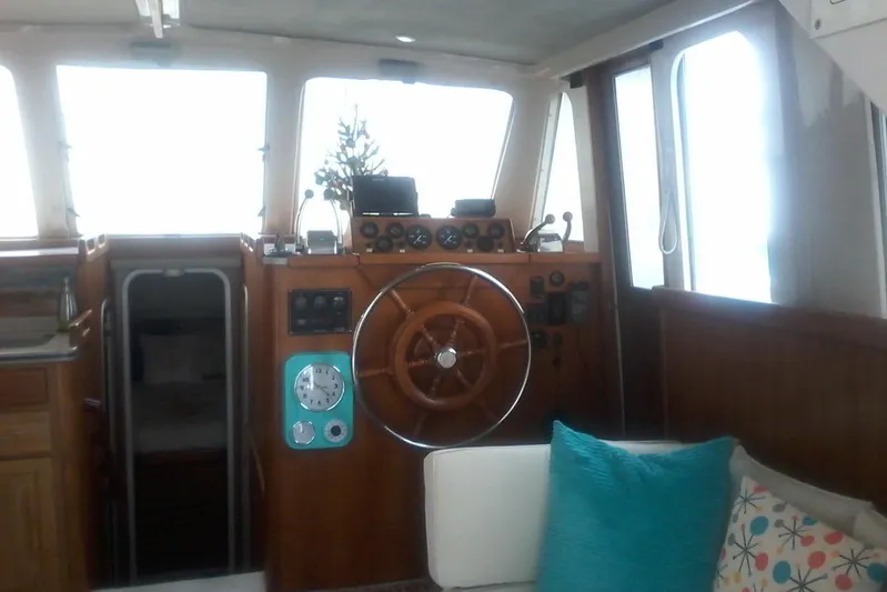 Lusea Yacht Photos Pics Interior of a 1997 Mainship 350 boat with wooden helm and cozy seating.