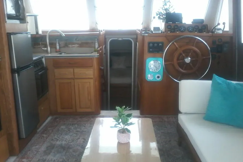 Lusea Yacht Photos Pics Interior of a 1997 Mainship 350 boat with helm, kitchen, and seating area.
