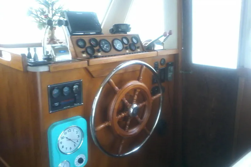 Lusea Yacht Photos Pics 1997 Mainship 350 helm with wooden wheel, gauges, and controls.