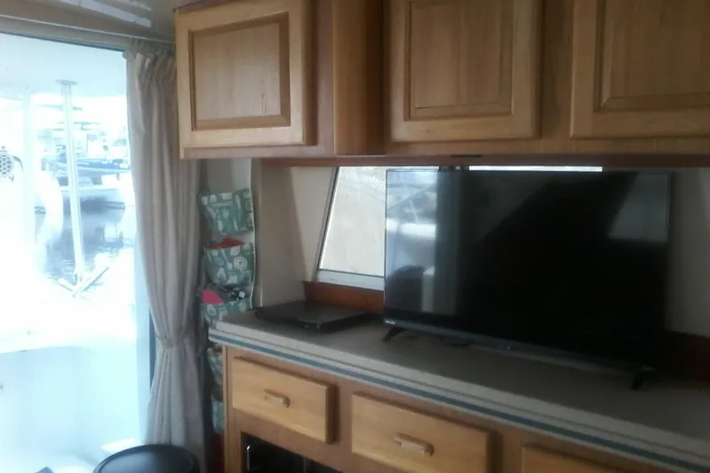 Lusea Yacht Photos Pics Interior of 1997 Mainship 350 with TV, wooden cabinets, and window view.