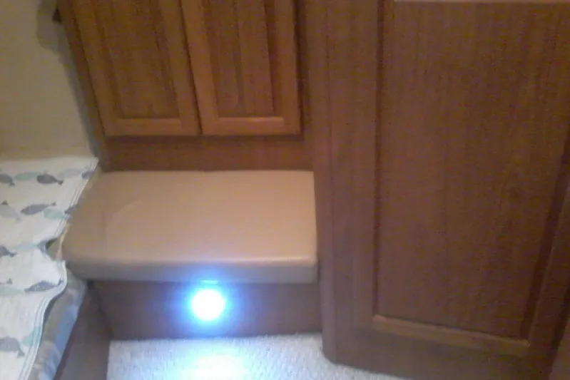 Lusea Yacht Photos Pics Interior of 1997 Mainship 350 boat with wooden cabinetry and cushioned seating.