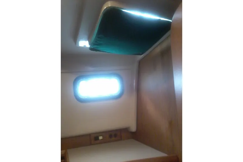 Lusea Yacht Photos Pics 1997 Mainship 350 cabin interior with window and wooden paneling.