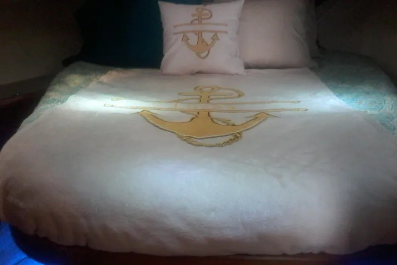 Lusea Yacht Photos Pics Cozy bed in 1997 Mainship 350 yacht with anchor-themed bedding and pillows.