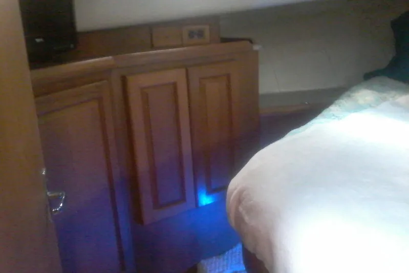 Lusea Yacht Photos Pics Interior cabin of 1997 Mainship 350 with wooden cabinetry and bed.