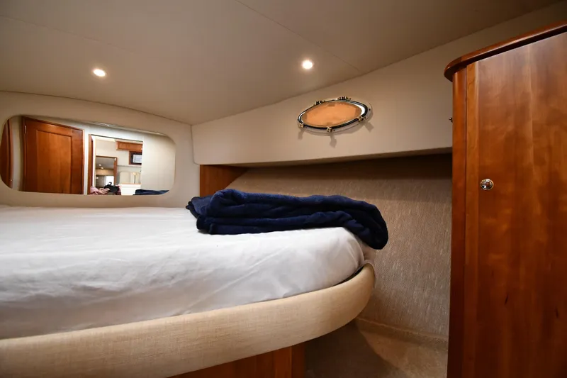 Lady Louise Yacht Photos Pics Cozy bedroom interior of 2000 Silverton 392 Motor Yacht with wooden cabinetry and soft lighting.