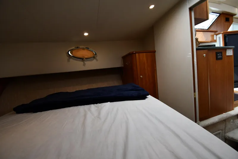 Lady Louise Yacht Photos Pics Interior cabin of 2000 Silverton 392 Motor Yacht with bed and wooden cabinetry.