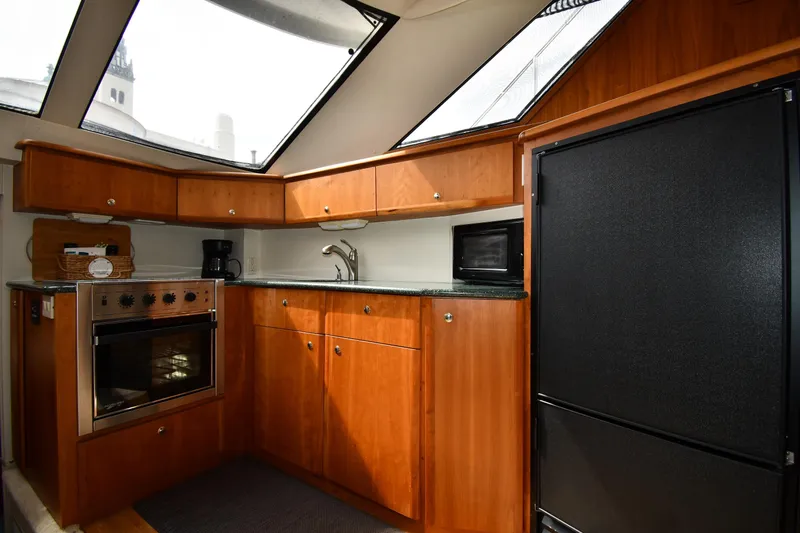 Lady Louise Yacht Photos Pics Luxurious kitchen interior of 2000 Silverton 392 Motor Yacht with wood cabinetry and modern appliances.