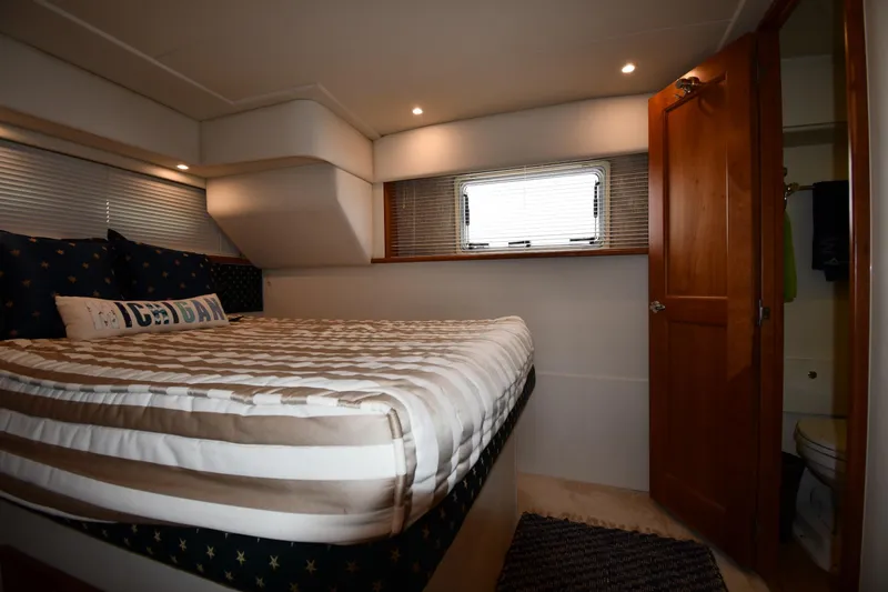 Lady Louise Yacht Photos Pics Cozy bedroom in 2000 Silverton 392 Motor Yacht with striped bedding and wooden door.