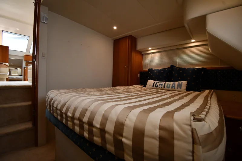 Lady Louise Yacht Photos Pics Interior of 2000 Silverton 392 Motor Yacht bedroom with striped bedding and cozy lighting.