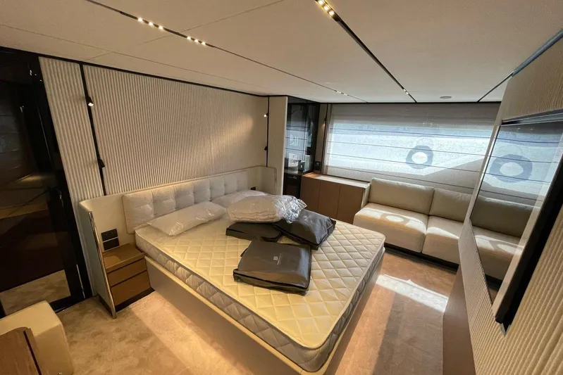  Yacht Photos Pics Luxurious bedroom interior of 2021 Ferretti Yachts 720 with modern furnishings and large window.