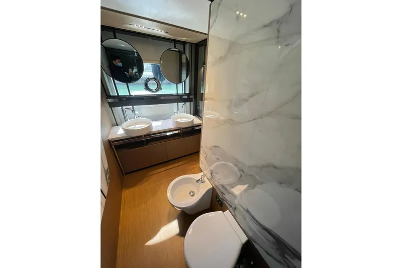  Yacht Photos Pics Luxurious bathroom in 2021 Ferretti Yachts 720 with dual sinks and marble accents.