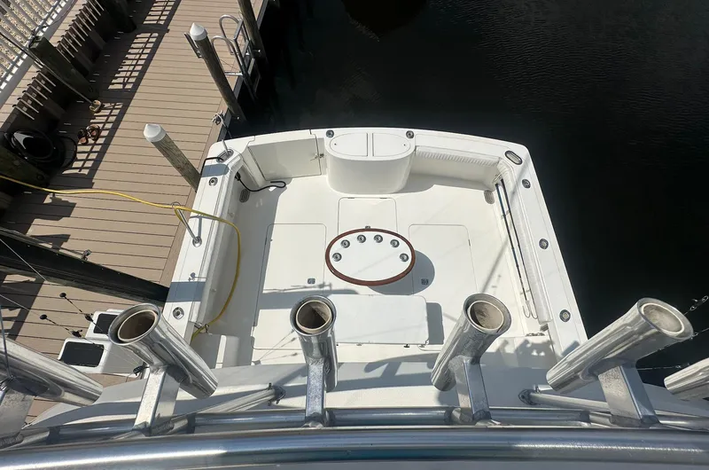 Current Addition Yacht Photos Pics 2006 Henriques 42 Convertible boat deck with fishing rod holders, docked at marina.