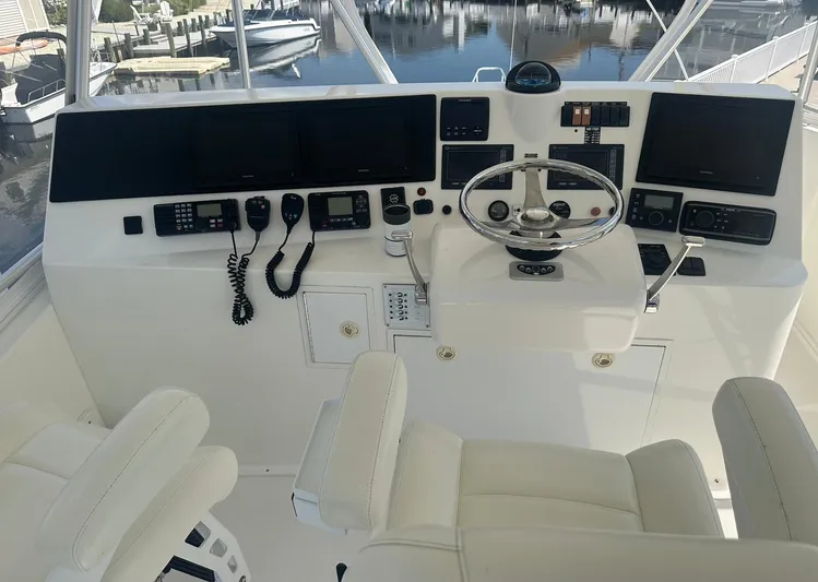 Current Addition Yacht Photos Pics Helm of 2006 Henriques 42 Convertible with navigation equipment and dual captain chairs.