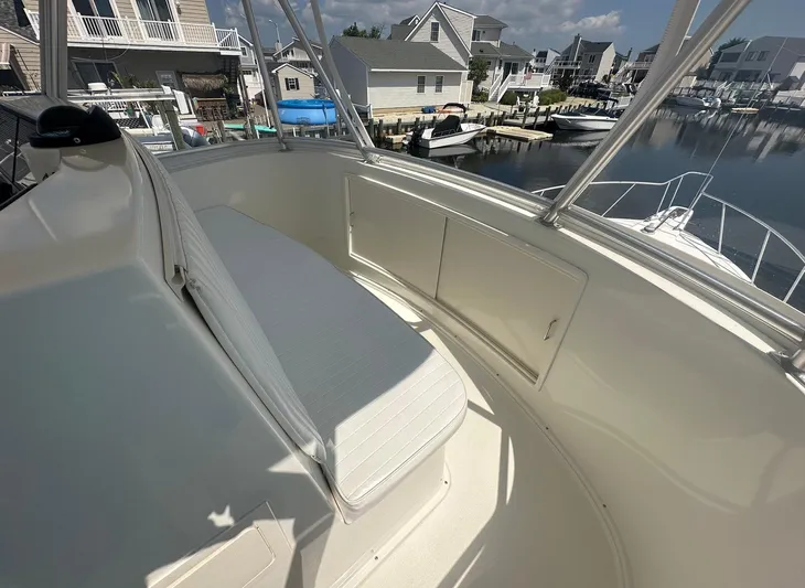 Current Addition Yacht Photos Pics 2006 Henriques 42 Convertible boat interior with seating, docked near waterfront homes.