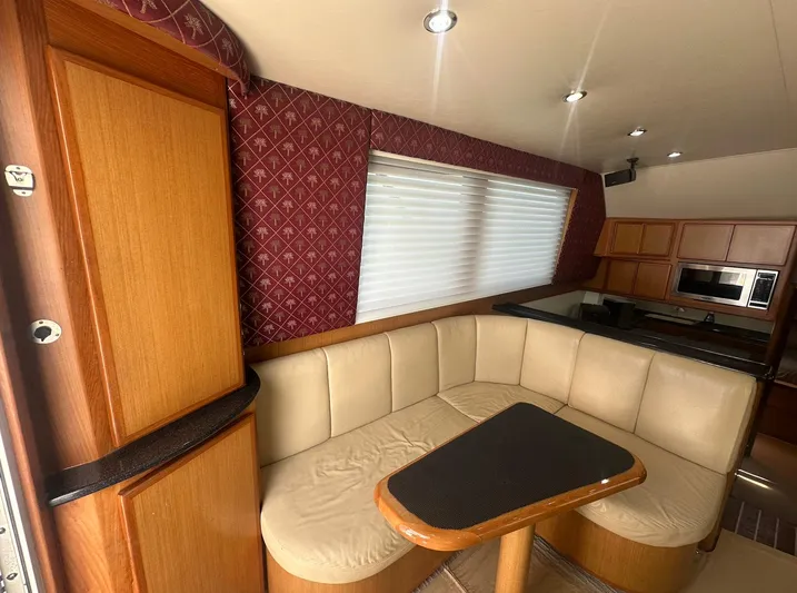 Current Addition Yacht Photos Pics Interior of 2006 Henriques 42 Convertible yacht with beige seating and wooden cabinetry.
