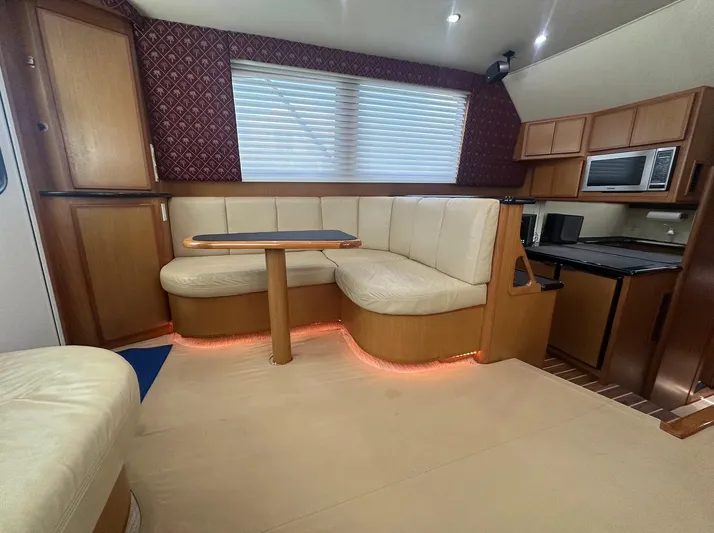 Current Addition Yacht Photos Pics Luxurious interior of a 2006 Henriques 42 Convertible yacht with cozy seating and modern kitchen.