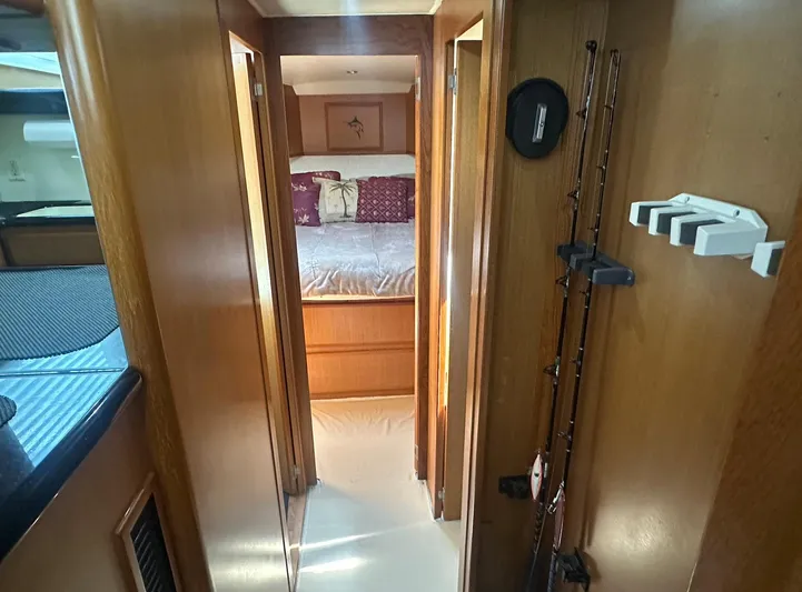 Current Addition Yacht Photos Pics Interior of 2006 Henriques 42 Convertible yacht, featuring cozy bedroom and fishing rods.