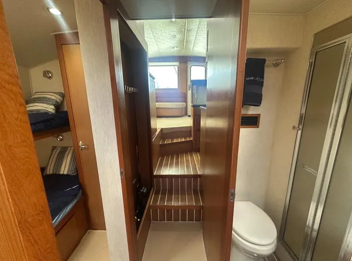 Current Addition Yacht Photos Pics 2006 Henriques 42 Convertible interior with bunk beds, bathroom, and steps leading to the cabin.
