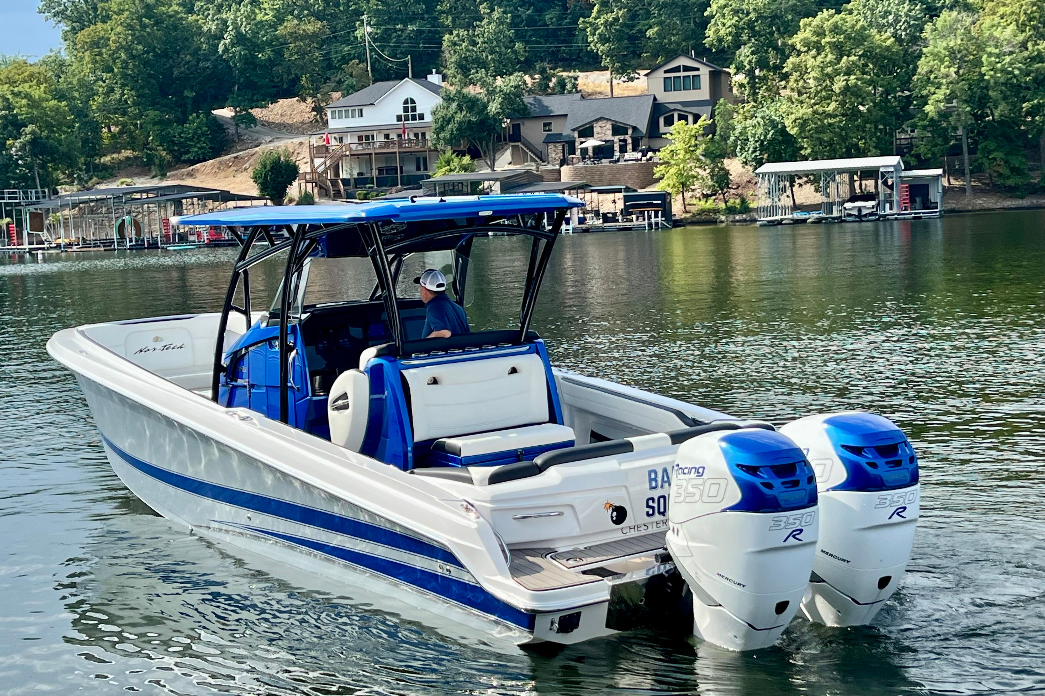 2020 Nor-Tech 340 Sport Center Console boat on a serene lake with lush greenery.