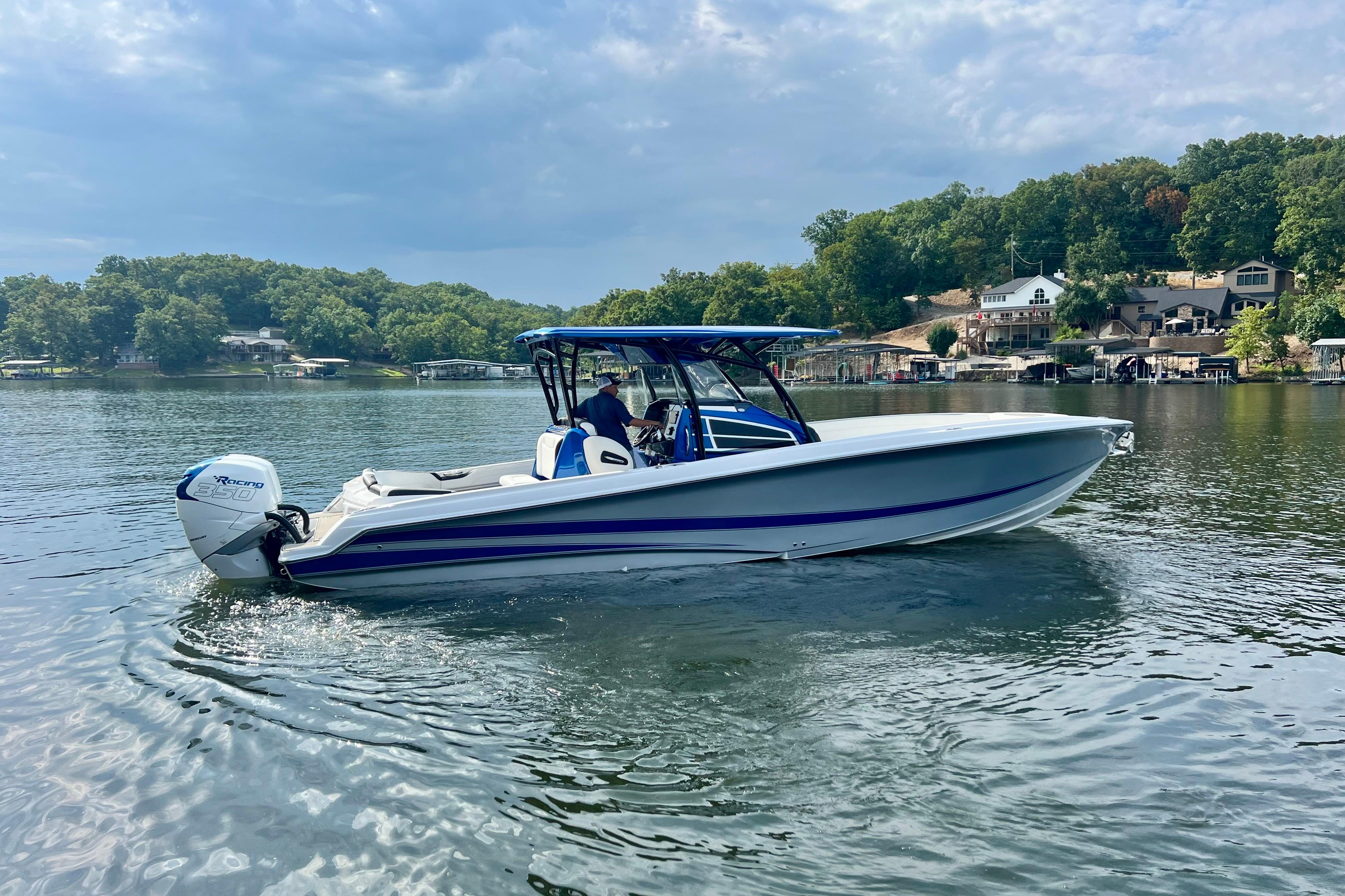 2020 Nor-Tech 340 Sport Center Console boat on a serene lake with lush greenery.