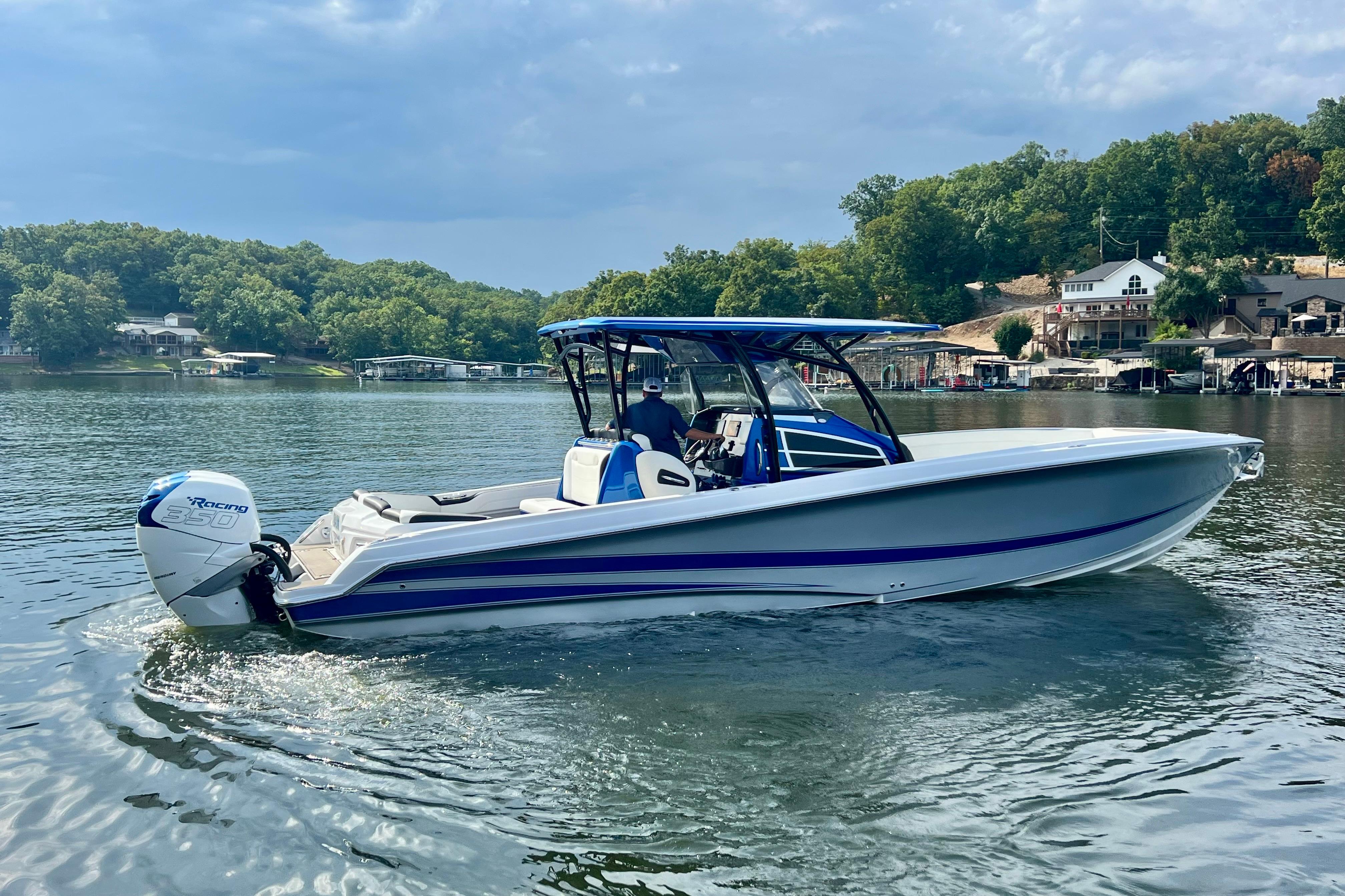2020 Nor-Tech 340 Sport Center Console boat cruising on a scenic lake.