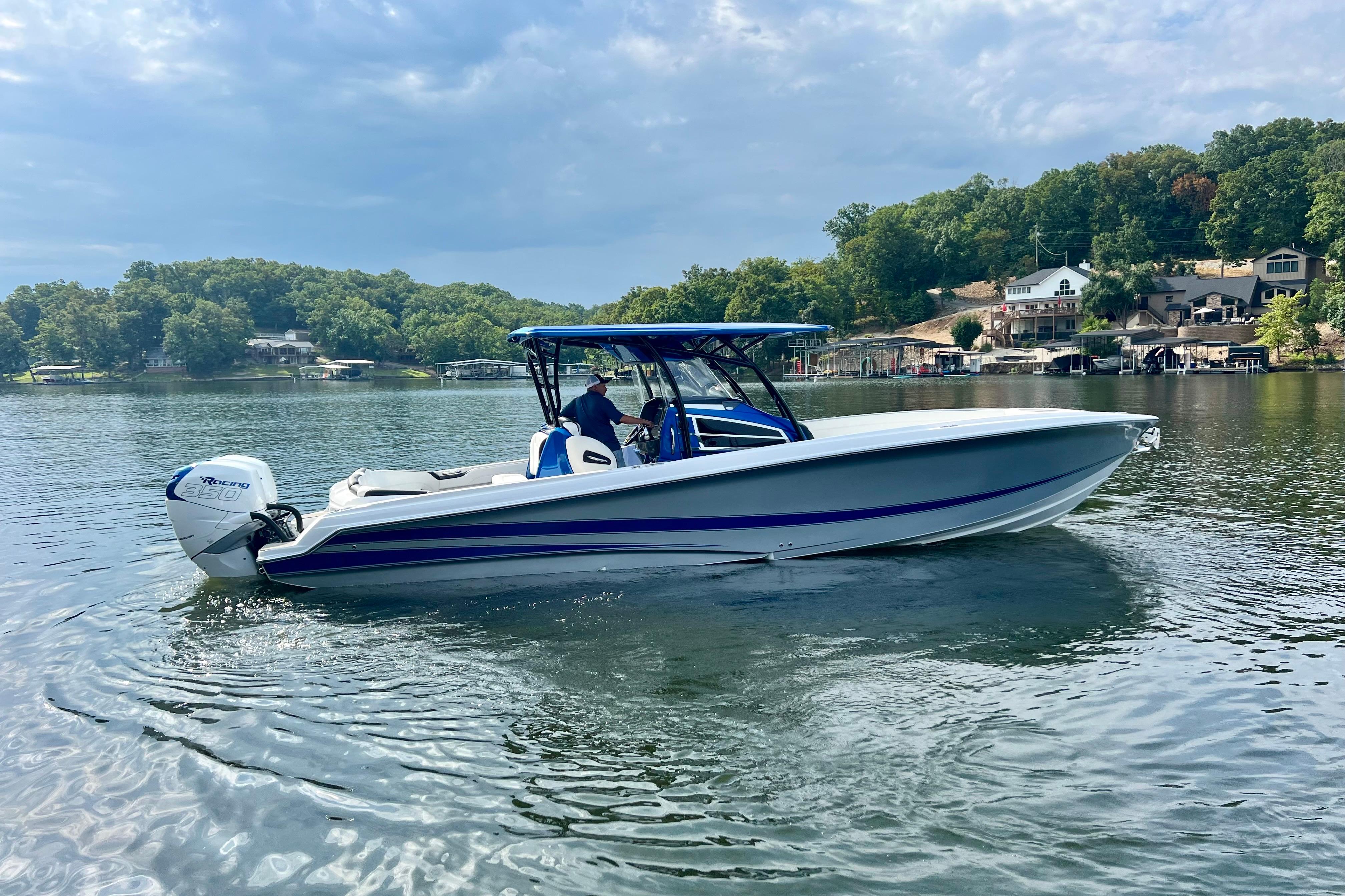 2020 Nor-Tech 340 Sport Center Console boat on a scenic lake with lush greenery.