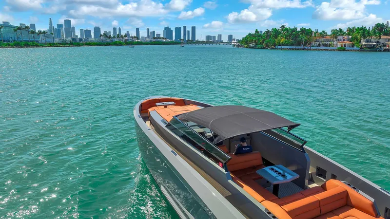 Spectra Yacht Photos Pics Vanquish Yachts VQ 45, 2021 model, cruising in a scenic coastal cityscape.