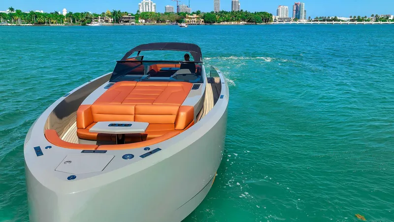 Spectra Yacht Photos Pics 2021 Vanquish Yachts VQ 45 cruising on turquoise waters near a city skyline.