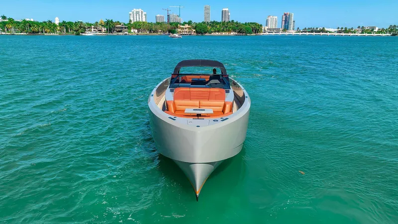 Spectra Yacht Photos Pics Vanquish Yachts VQ 45, 2021 model, cruising on turquoise waters with city skyline backdrop.