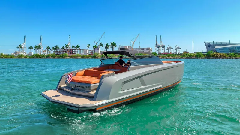 Spectra Yacht Photos Pics Vanquish Yachts VQ 45, 2021 model, cruising on clear blue water with cityscape background.