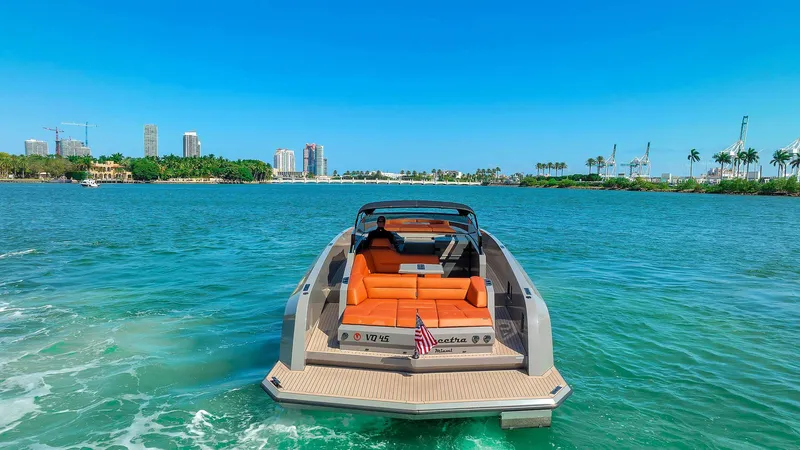 Spectra Yacht Photos Pics 2021 Vanquish Yachts VQ 45 on water, luxury yacht with orange seating, city skyline background.