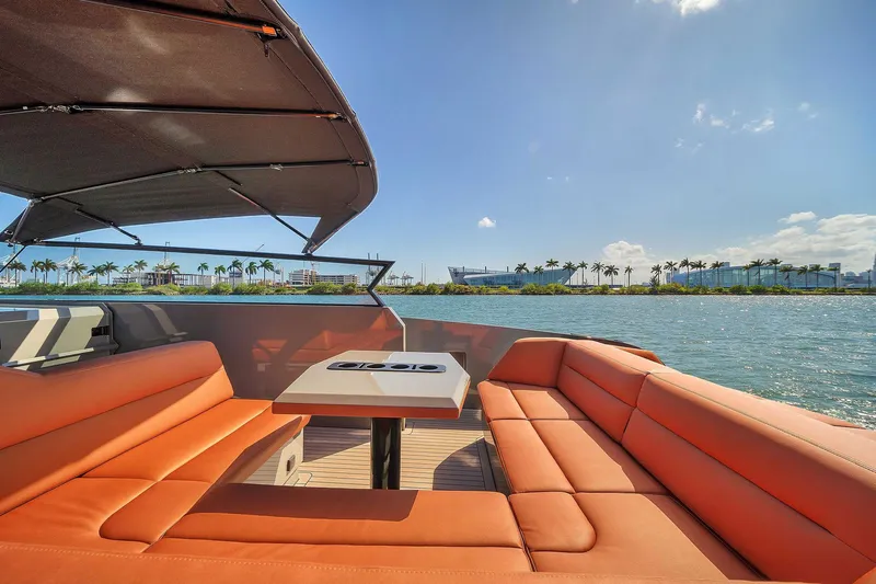 Spectra Yacht Photos Pics Luxurious 2021 Vanquish Yachts VQ 45 with orange seating, scenic waterfront view.