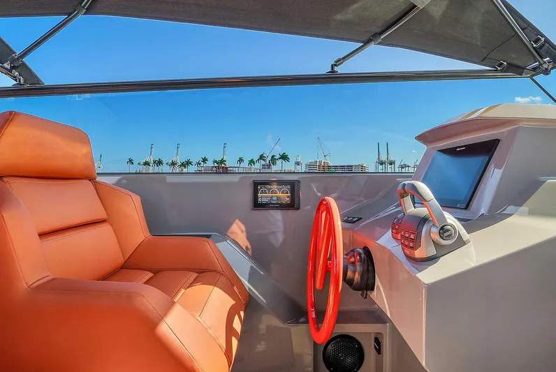 Spectra Yacht Photos Pics Interior of 2021 Vanquish Yachts VQ 45 with orange seating and modern helm controls.