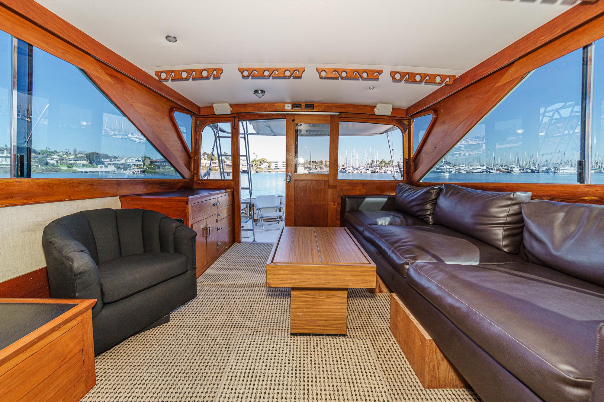 Interior of a 1974 Pacemaker Sportfisher yacht with leather sofa and harbor view.