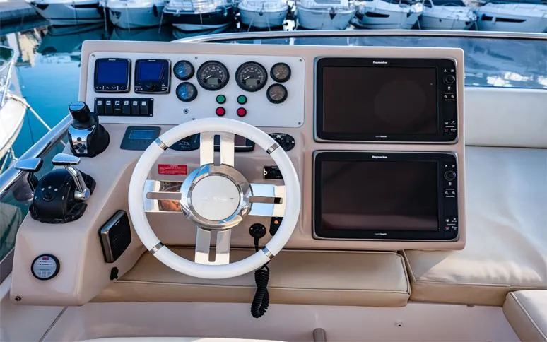 Yacht Photos Pics Control panel of a 2014 Azimut 64 yacht with steering wheel and navigation screens.