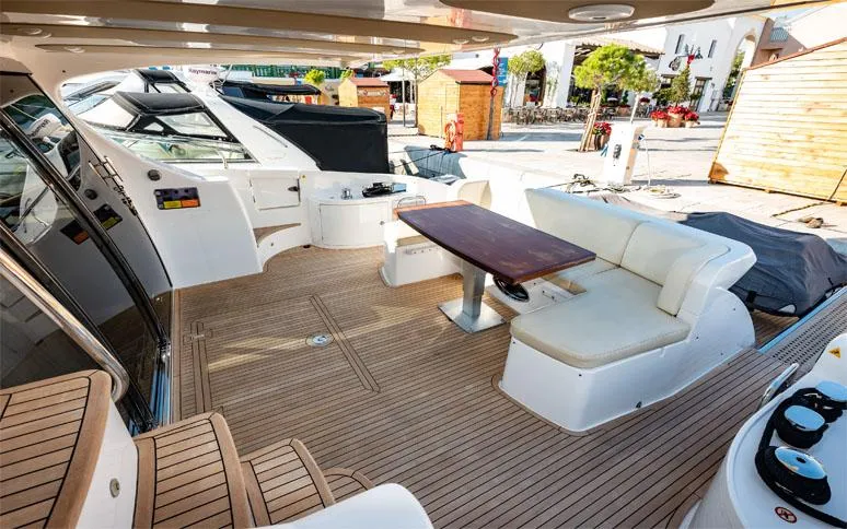  Yacht Photos Pics Luxurious 2014 Azimut 64 yacht deck with seating and table, docked at marina.