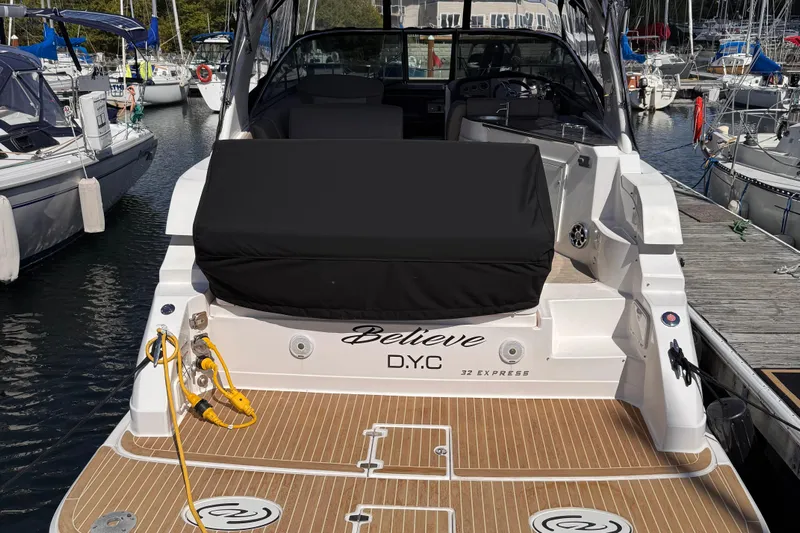  Yacht Photos Pics 2015 Regal 32 Express boat docked at marina, rear view with covered seating area.