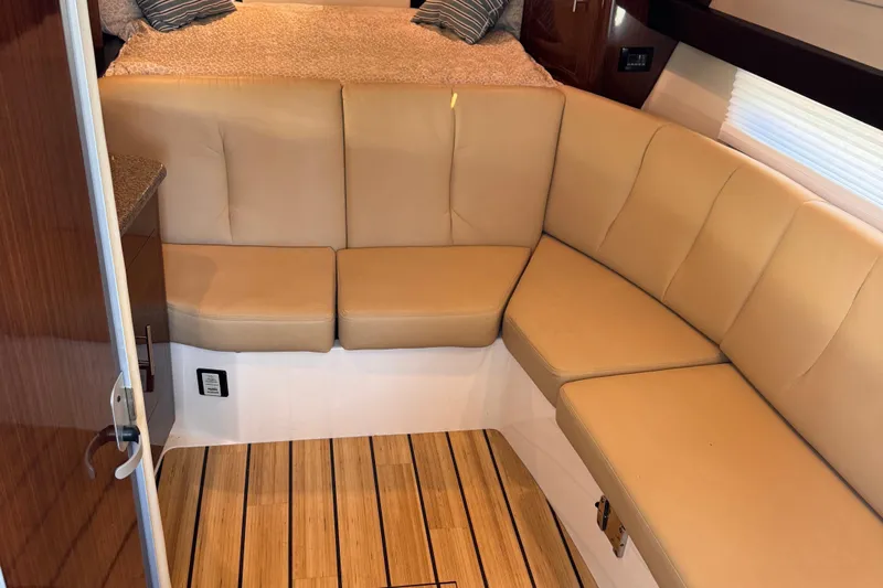  Yacht Photos Pics Interior of 2015 Regal 32 Express boat with beige seating and wooden flooring.