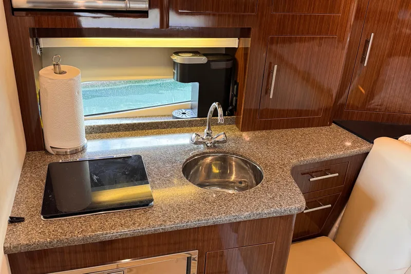  Yacht Photos Pics 2015 Regal 32 Express yacht kitchen with granite countertop, sink, and modern appliances.